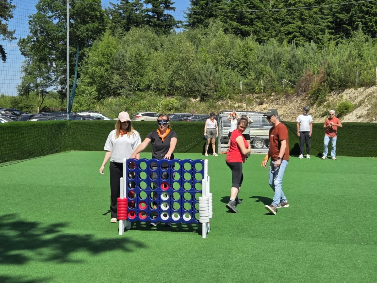 Groupe de teambuilding jouant à une activité avec un puissance 4 géant